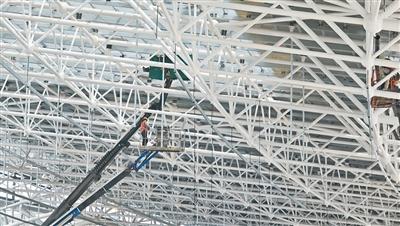 济南遥墙国际机场二期改扩建工程T2航站楼项目现场，工人进行檐口吊顶施工。孙裕泽摄
